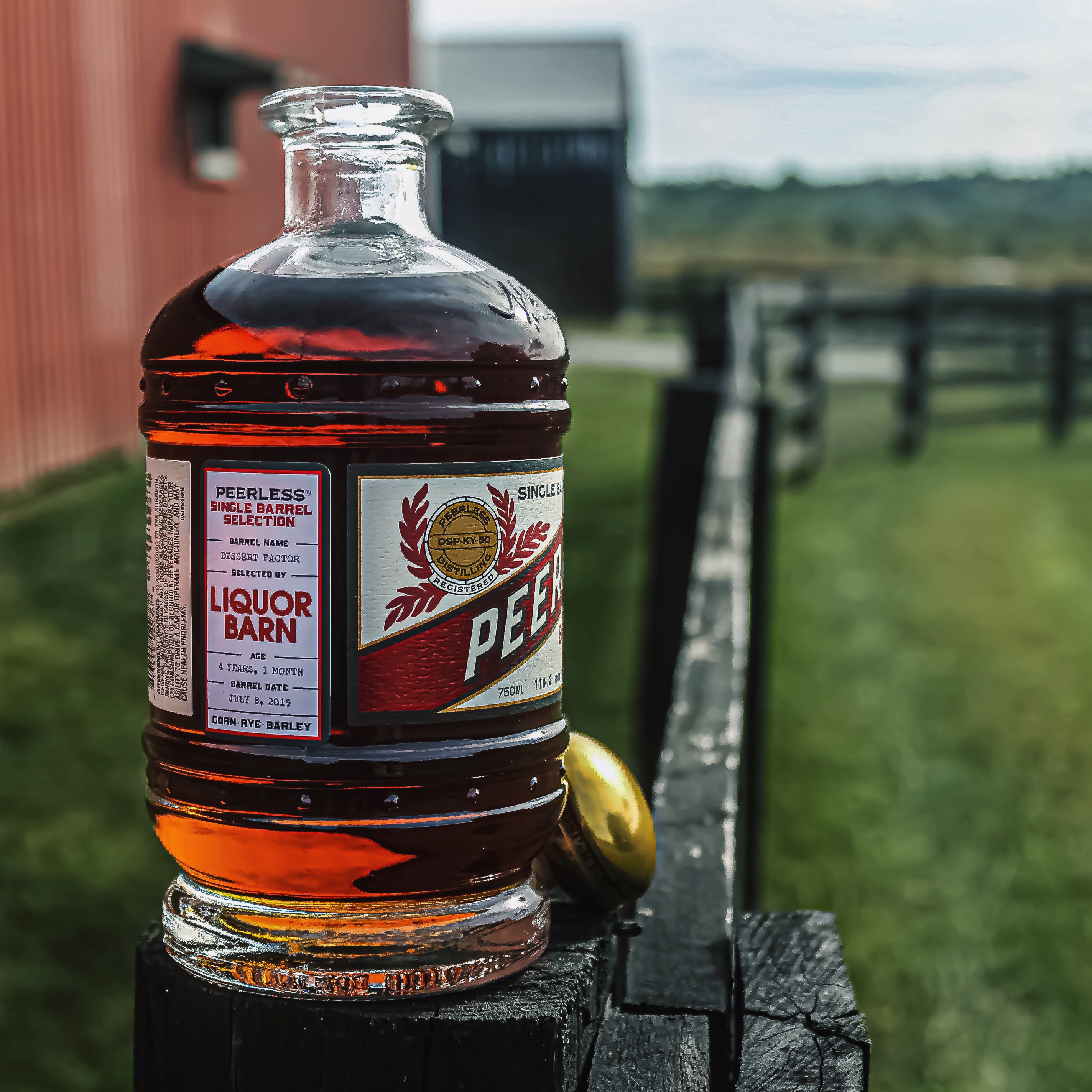 Bourbon bottle with a barn in the background