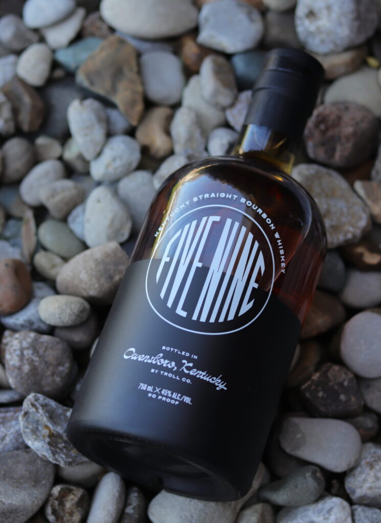 Bourbon bottle on rocks in a garden.