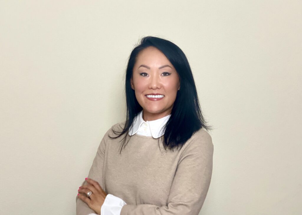 Liz Brusca standing against a wall for a professional head shot