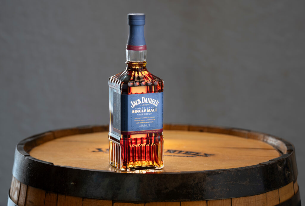 Jack Daniel's American Single Malt sitting on a bourbon barrel