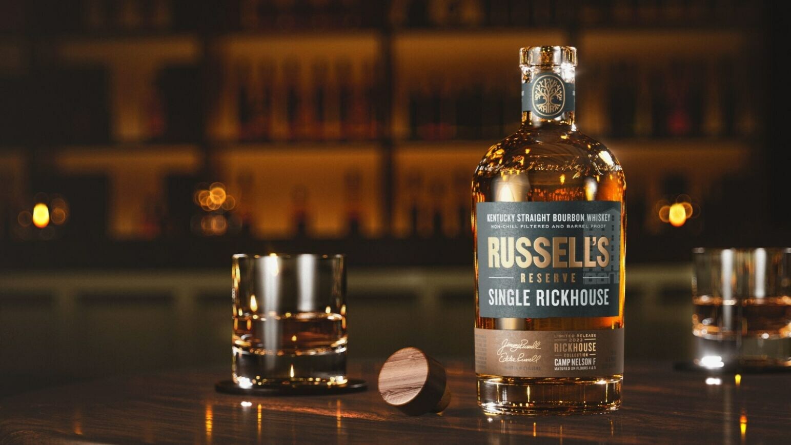 A bottle of Kentucky Bourbon from Wild Turkey Distillery on a bar with glassware.