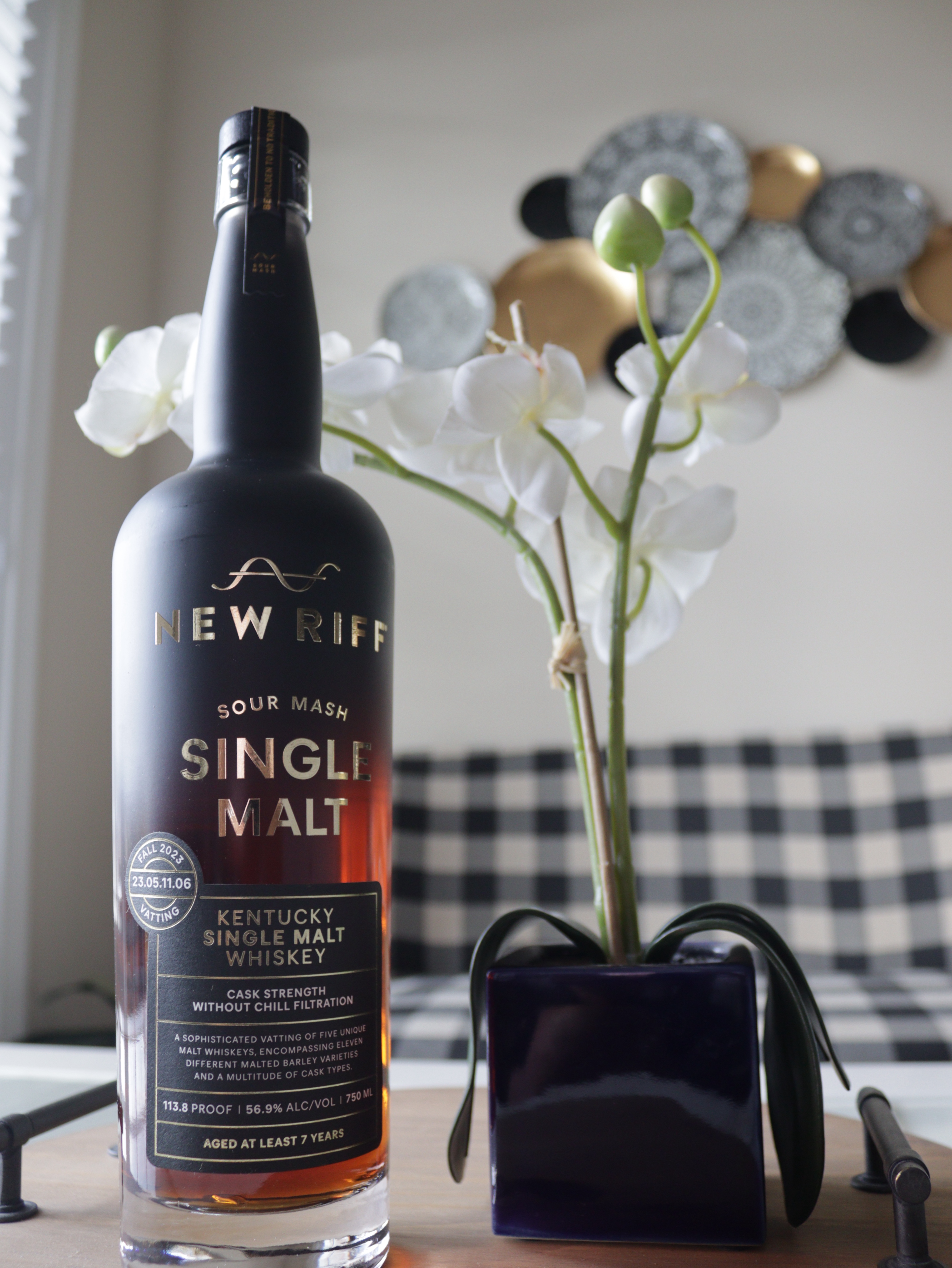 New Riff Single Malt with flower and couch in the background