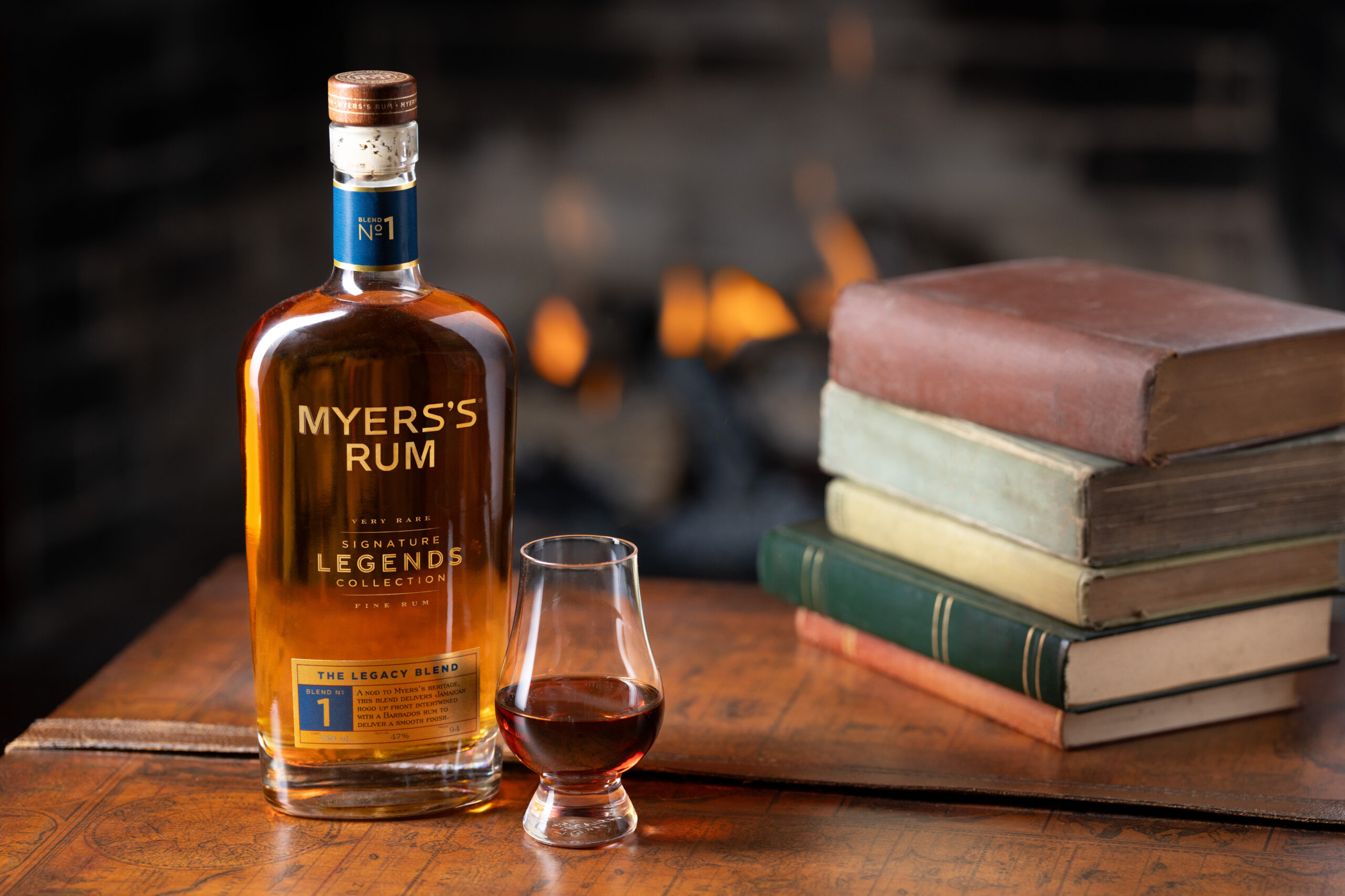 Bottle on a table with a glass and books