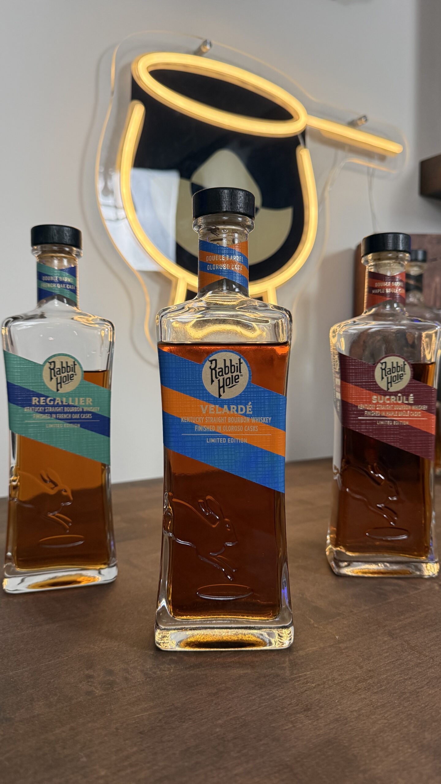 Rabbit Hole Distillery Exclusives Bottles With Bourbon Lens Logo in the background